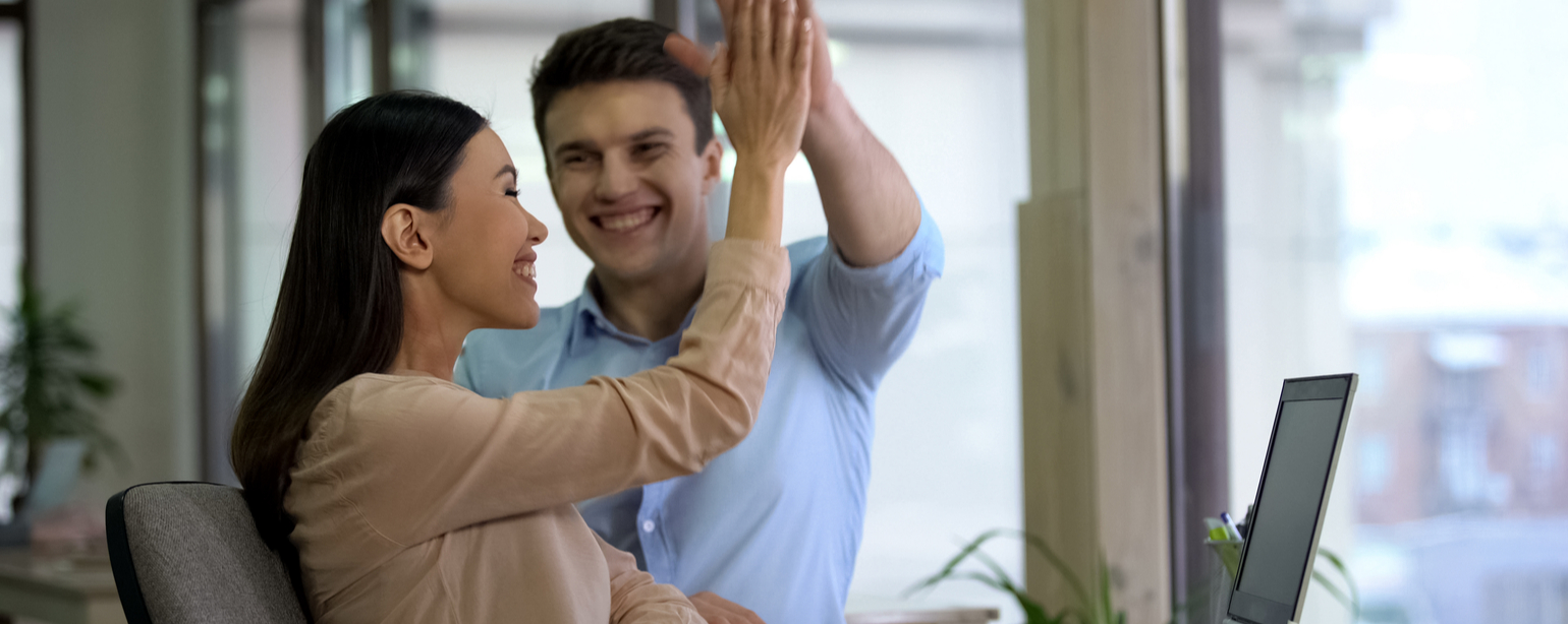 Happy professionals giving high five and smiling