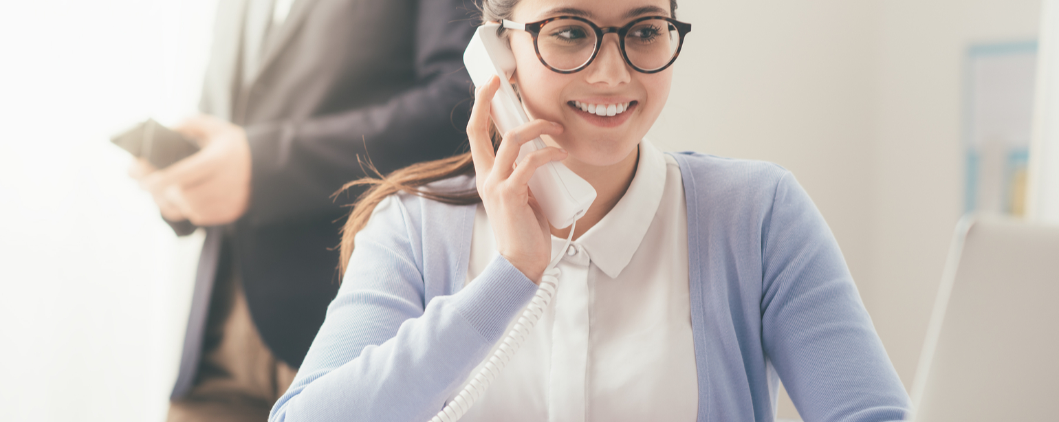 Efficient smiling secretary answering phone calls and talking with customers
