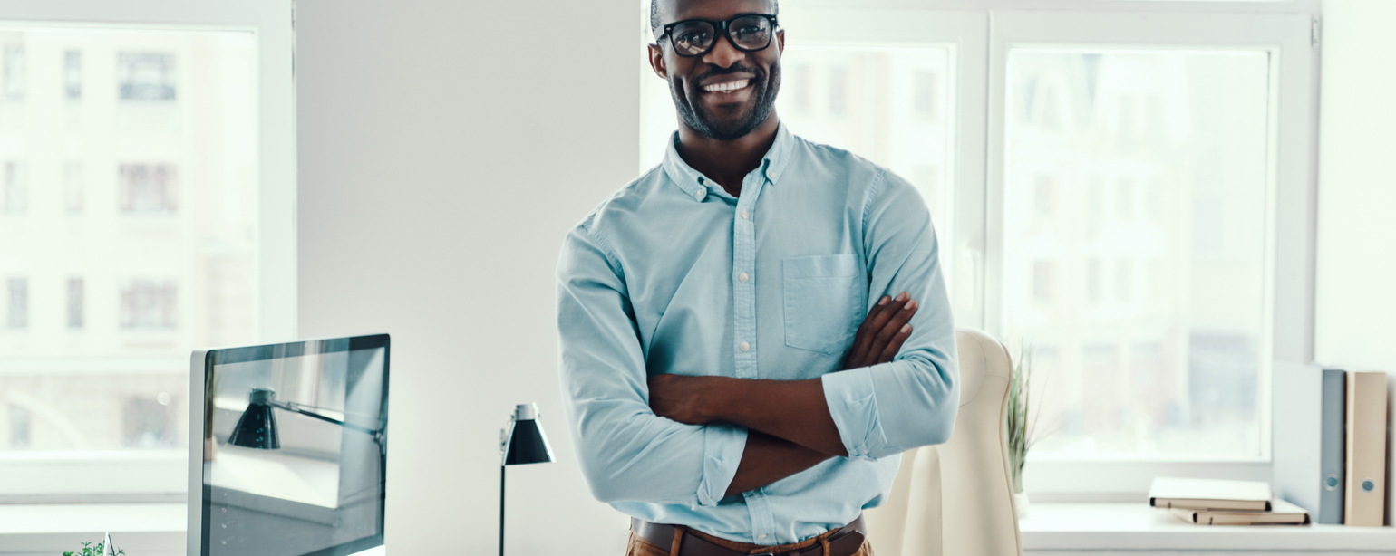 Handsome young black man standing in office looking into camera