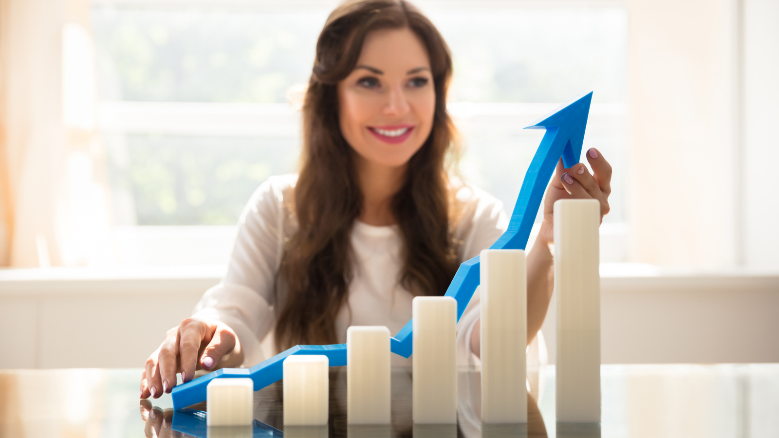 Increasing Graph In Front Of Happy Young Businesswoman Holding Blue Arrow