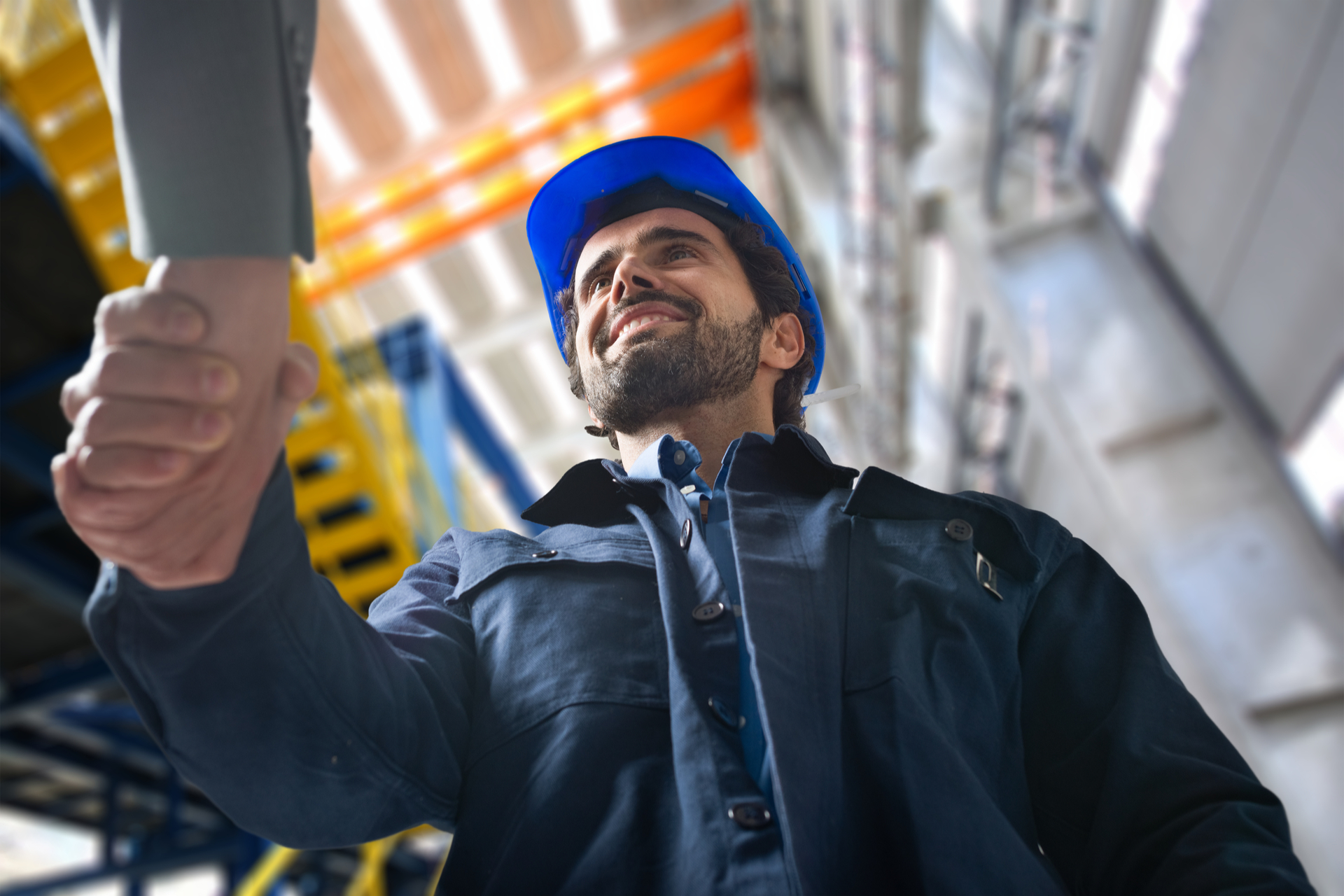 Portrait of a man giving an handshake in an industrial facility