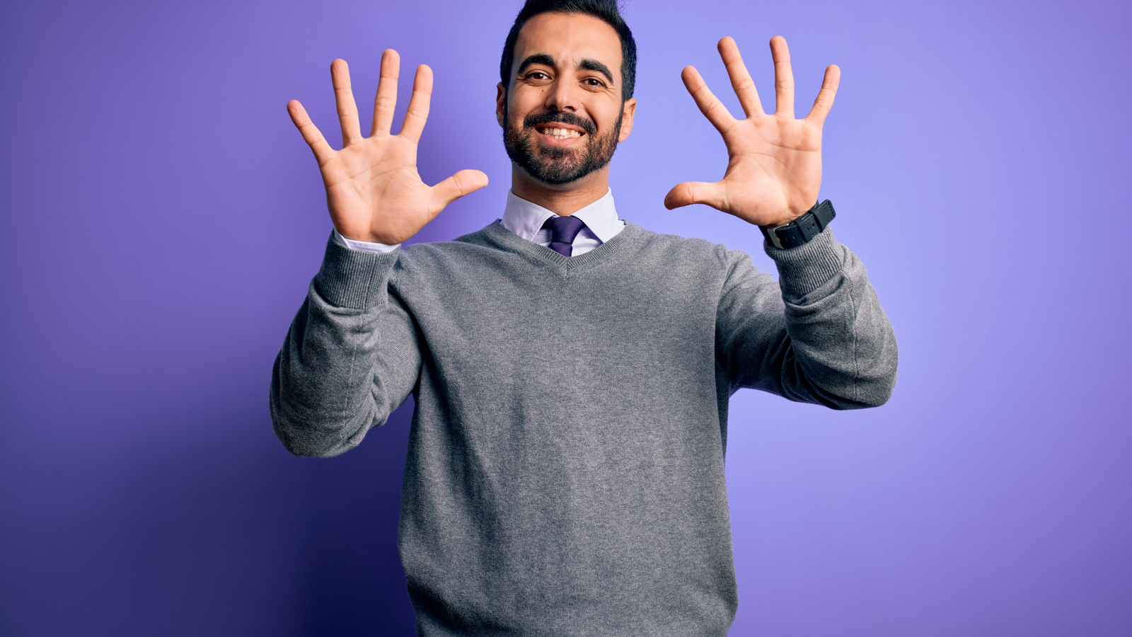 businessman wearing casual tie standing over isolated purple background showing and pointing up with fingers number ten