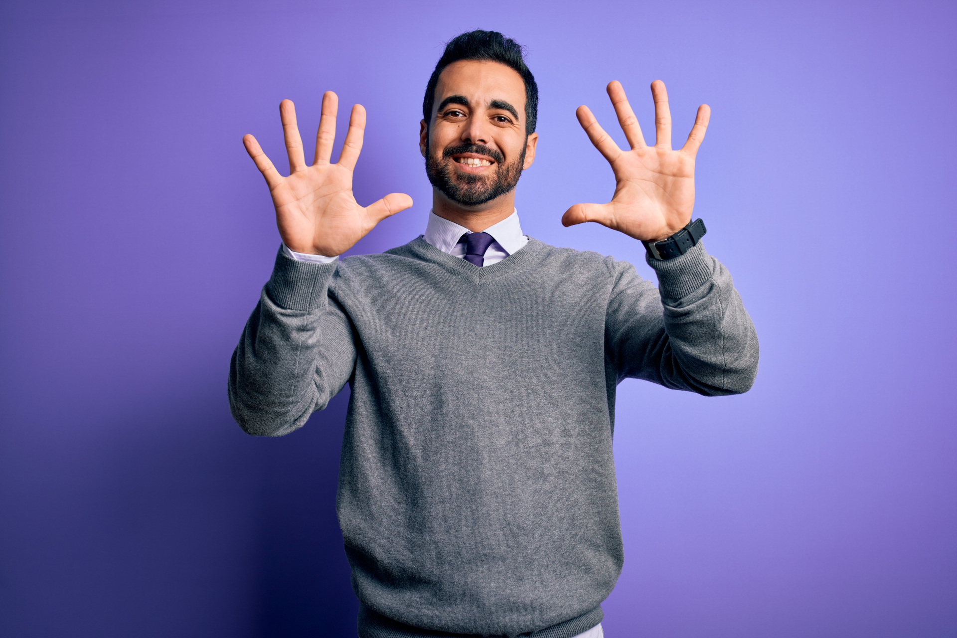 businessman wearing casual tie standing over isolated purple background showing and pointing up with fingers number ten