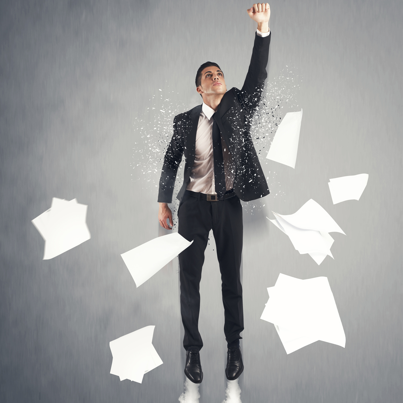 man dressed in an office formals throwing the pile of papers in the air