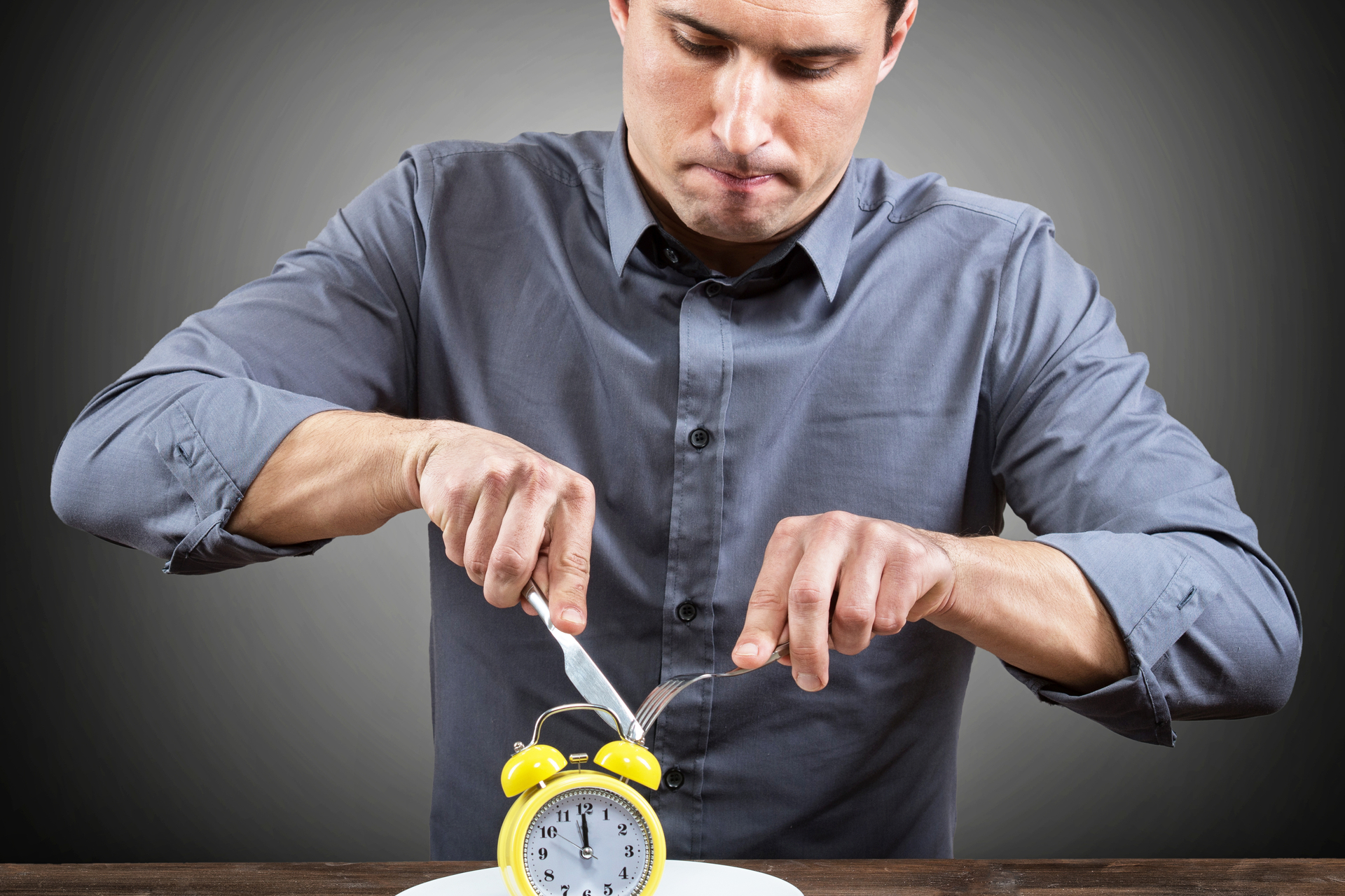 man cutting clock sitting on plate