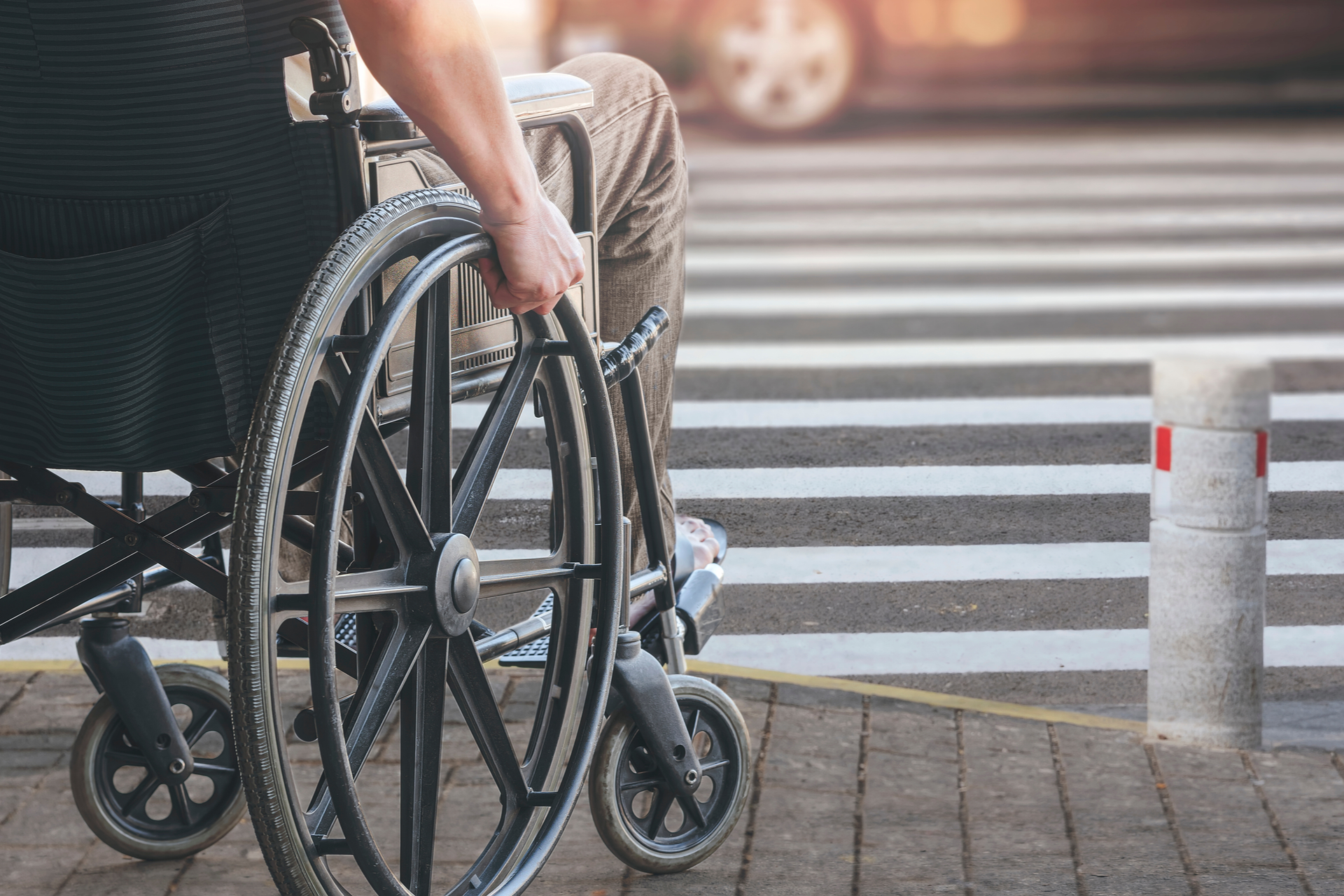 man on wheelchair preparing to cross the road on pedestrian crossing