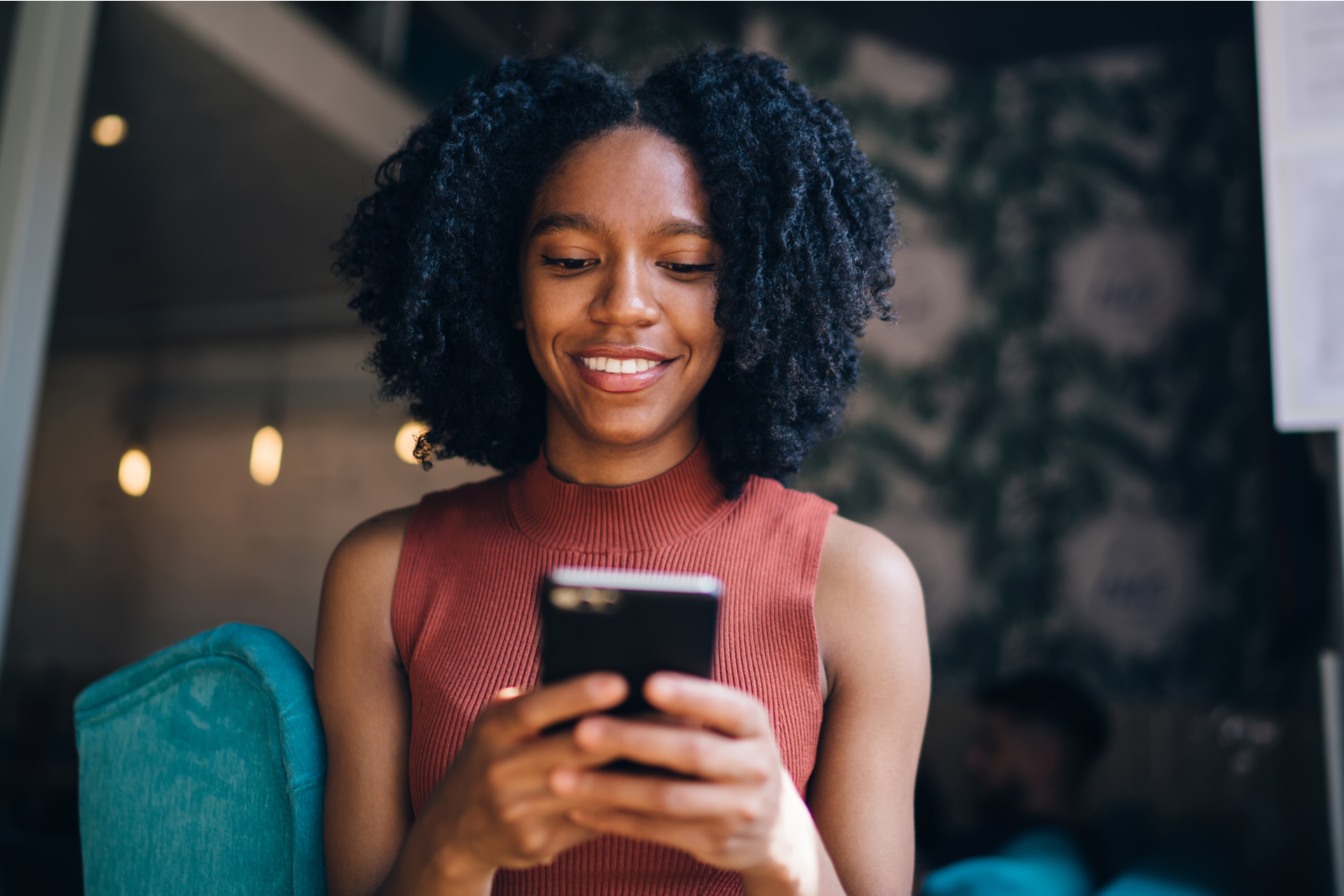 positive black woman using phone to communicate via text message